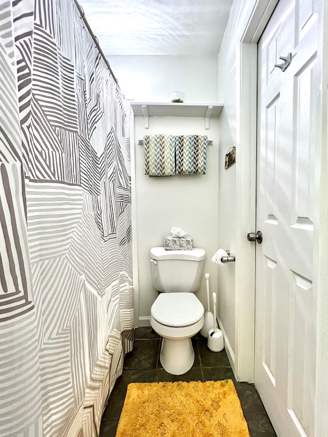 bathroom featuring toilet and tile patterned flooring