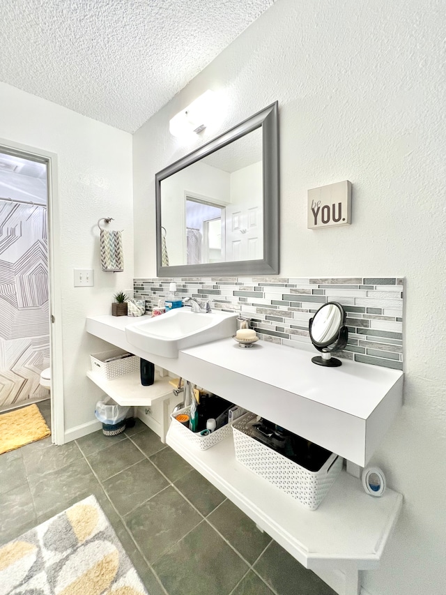 bathroom with sink, tile patterned floors, toilet, and decorative backsplash