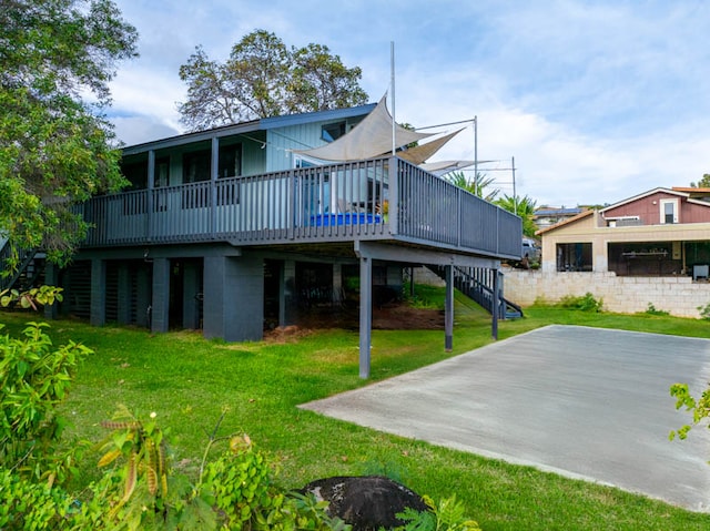 back of house featuring a lawn and a deck