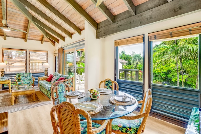 sunroom / solarium with a healthy amount of sunlight, wooden ceiling, and vaulted ceiling with beams