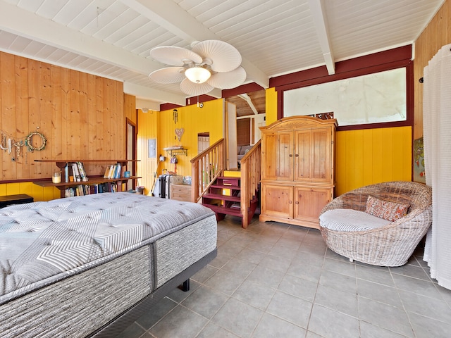 tiled bedroom featuring wood walls, beam ceiling, and ceiling fan