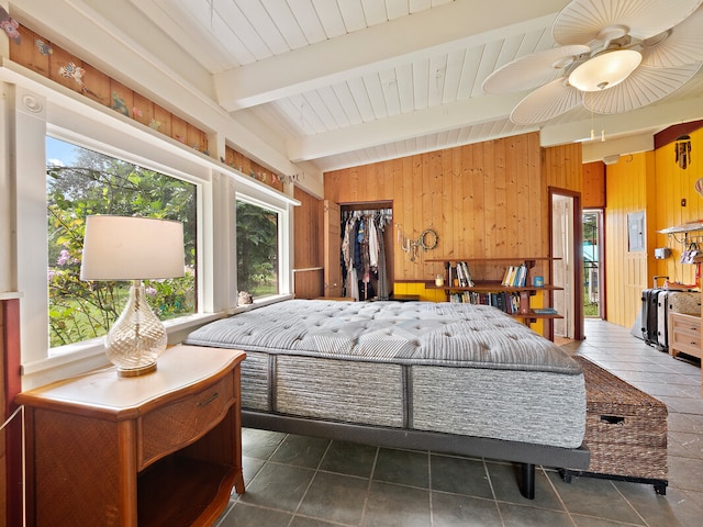 bedroom featuring vaulted ceiling with beams, multiple windows, wooden walls, and ceiling fan