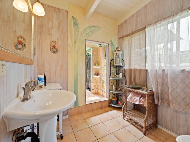 bathroom with beam ceiling, wood walls, and tile patterned flooring