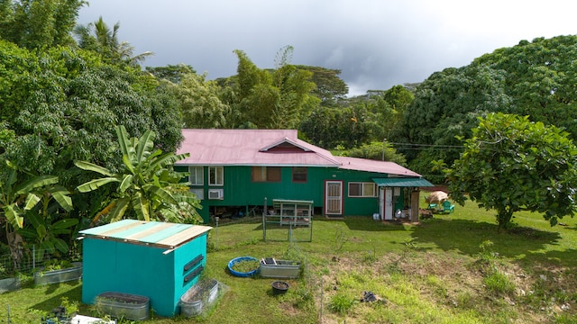 back of property with a yard and a shed