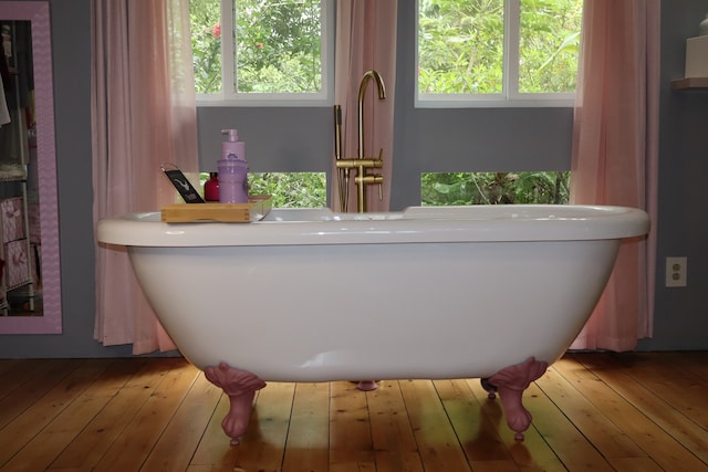 bathroom featuring wood-type flooring and a tub