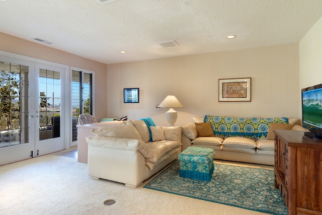 living room with carpet flooring, a textured ceiling, and french doors