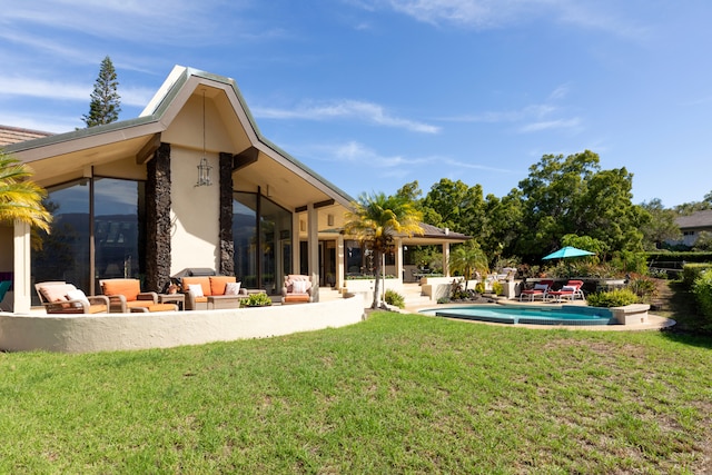 rear view of property featuring a patio, outdoor lounge area, and a lawn