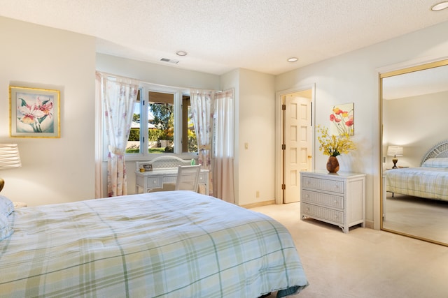 bedroom featuring light carpet, a closet, and a textured ceiling