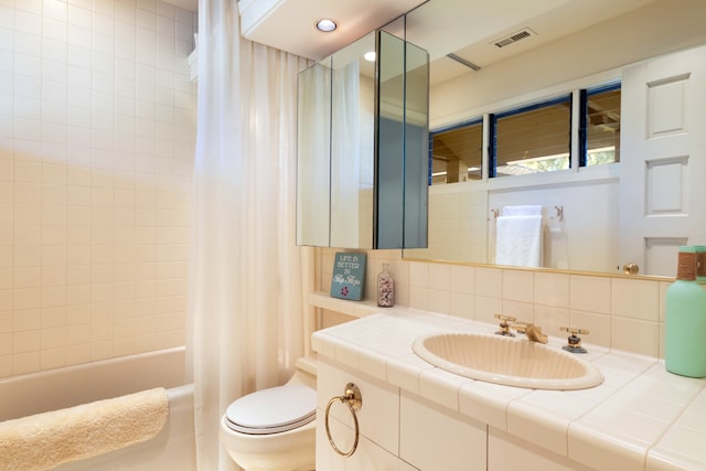 full bathroom with shower / tub combo, backsplash, vanity, and toilet