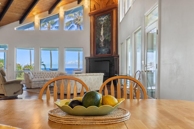 dining space with beamed ceiling, high vaulted ceiling, and wooden ceiling