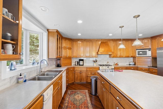 kitchen with backsplash, sink, custom exhaust hood, and white appliances