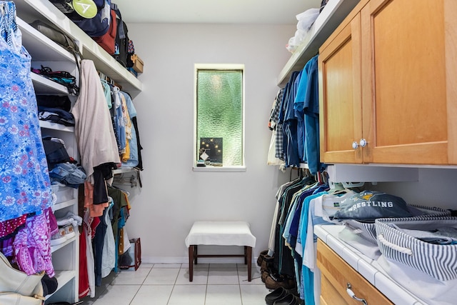 walk in closet with light tile patterned floors