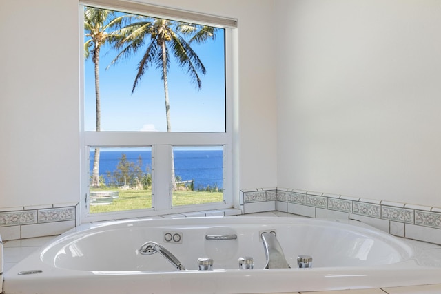 bathroom featuring a relaxing tiled tub and a water view