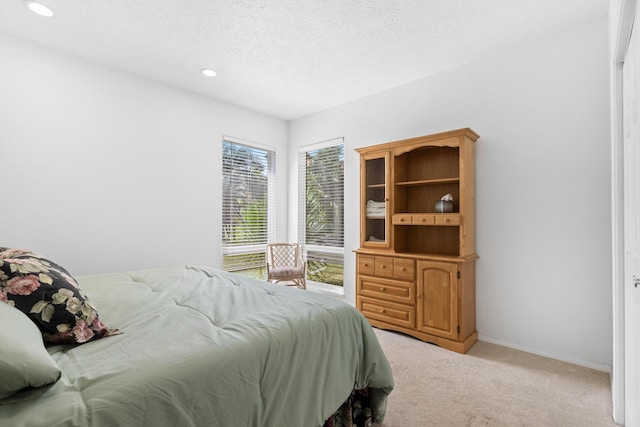 bedroom with light carpet and a textured ceiling