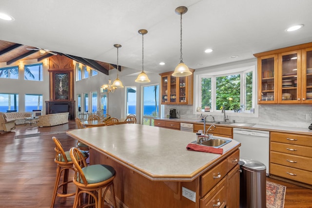 kitchen with tasteful backsplash, an island with sink, lofted ceiling with beams, white dishwasher, and dark hardwood / wood-style floors