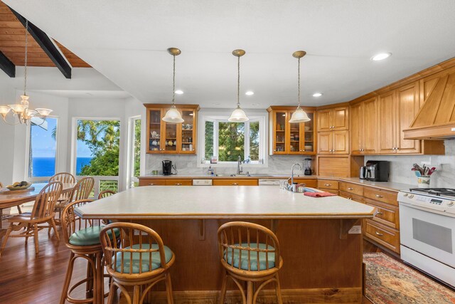 kitchen with backsplash, beamed ceiling, white range oven, a water view, and a center island with sink