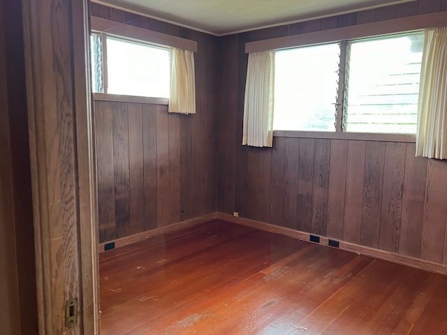 unfurnished room with wood ceiling and wooden walls