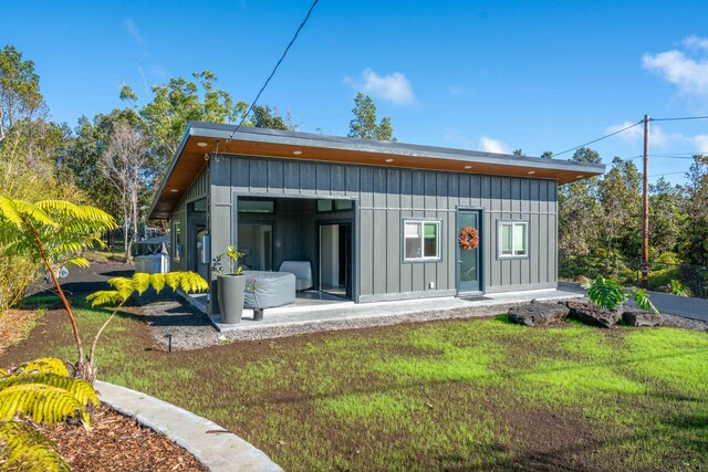 back of house featuring a lawn and a patio