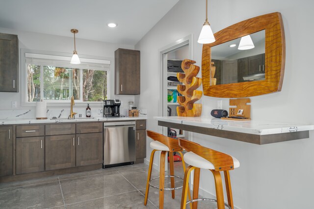 kitchen with dark brown cabinets, vaulted ceiling, stainless steel dishwasher, and hanging light fixtures