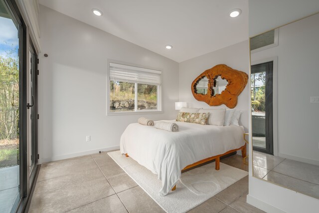 bedroom featuring access to exterior, vaulted ceiling, and light tile patterned flooring