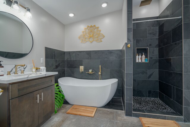 bathroom with vanity, tile walls, and shower with separate bathtub