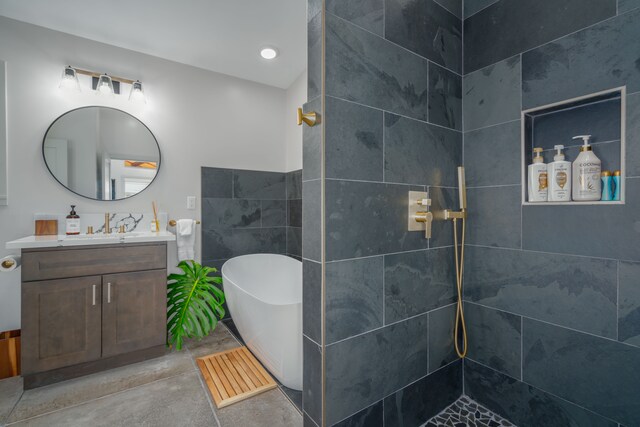 bathroom with plus walk in shower, tile patterned flooring, vanity, and tile walls