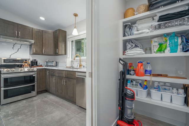 kitchen featuring dark brown cabinetry, sink, pendant lighting, vaulted ceiling, and appliances with stainless steel finishes