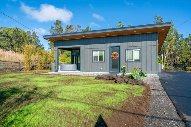 exterior space featuring a hot tub and a front lawn