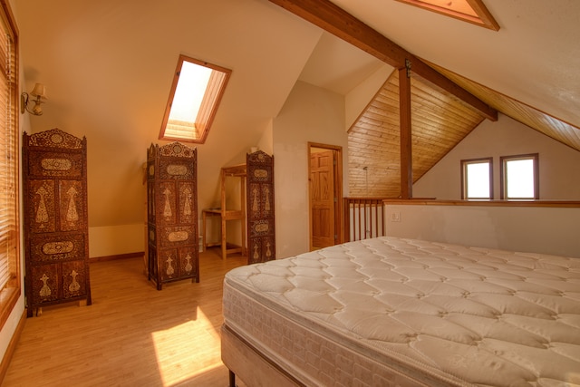 bedroom with vaulted ceiling with skylight and light wood-type flooring