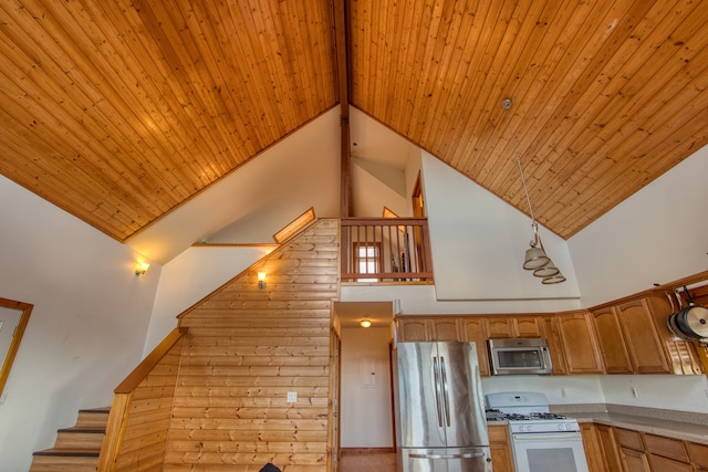 kitchen featuring decorative light fixtures, wooden ceiling, stainless steel appliances, and high vaulted ceiling