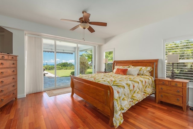 bedroom with access to outside, multiple windows, hardwood / wood-style flooring, and ceiling fan