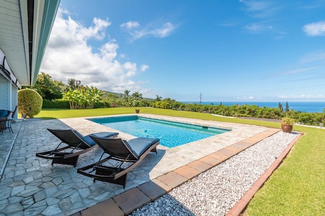 view of swimming pool featuring a water view, a patio area, and a yard