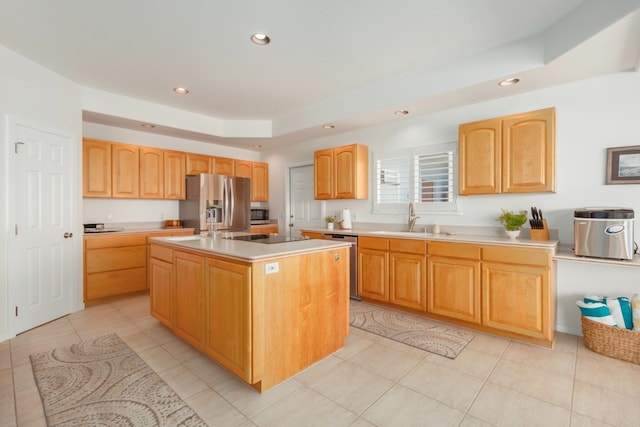 kitchen with appliances with stainless steel finishes, sink, light tile patterned floors, and an island with sink