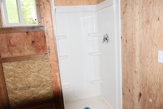 bathroom with a shower and wooden walls