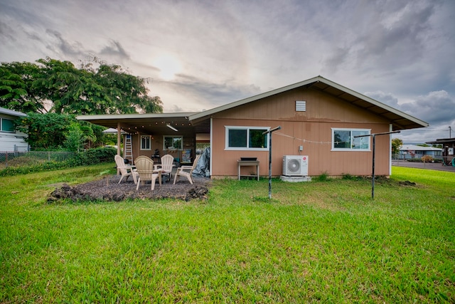 rear view of property with ac unit, a patio, and a lawn