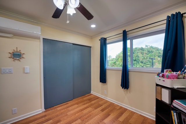 bedroom with a closet, an AC wall unit, crown molding, light wood-type flooring, and ceiling fan