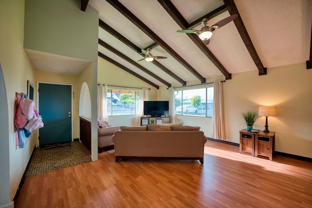 living room featuring a textured ceiling, light hardwood / wood-style floors, ceiling fan, beamed ceiling, and high vaulted ceiling