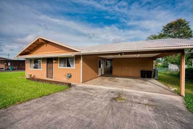 ranch-style house with a carport and a front lawn