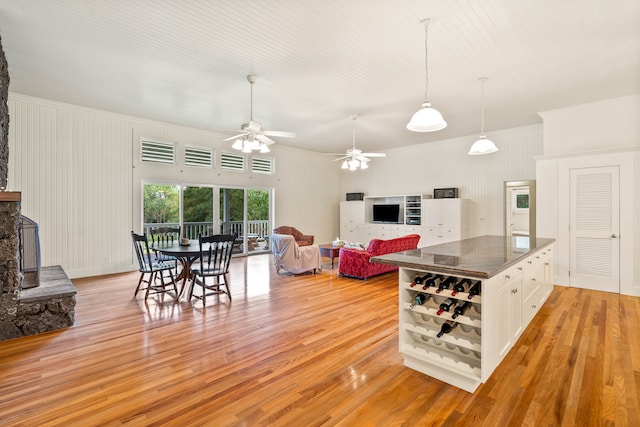 kitchen with crown molding, white cabinets, a fireplace, and light wood-type flooring