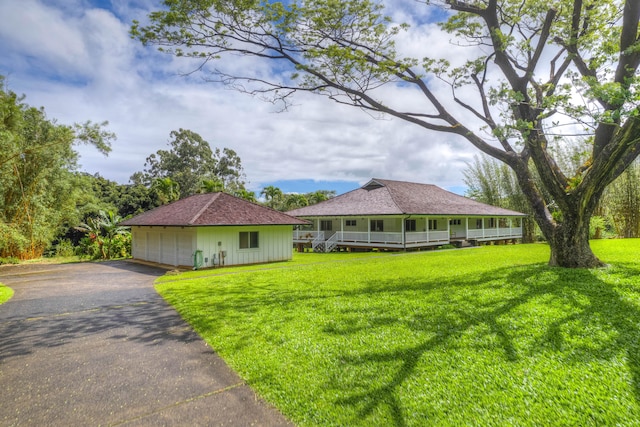 6140 Kahiliholo Rd, Kilauea, HI 96754 - view of front of house with covered porch, a garage, a front yard, and an outbuilding