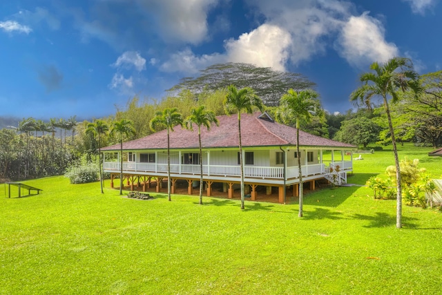 6140 Kahiliholo Rd, Kilauea, HI 96754 - rear view of house with a lawn, a wooden deck, and board and batten siding