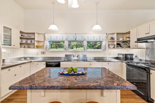 kitchen with stainless steel counters, a kitchen bar, black appliances, sink, and a center island