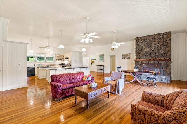 6140 Kahiliholo Rd, Kilauea, HI 96754 - living area with a ceiling fan, light wood-style floors, and a stone fireplace