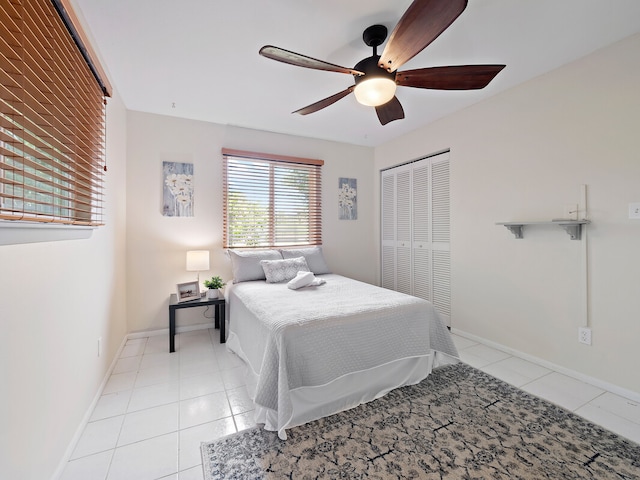 bedroom with light tile patterned floors, a closet, and ceiling fan