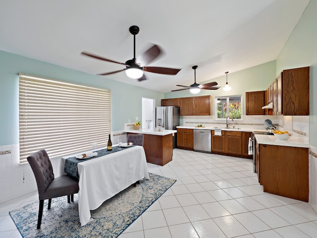 kitchen with sink, stainless steel appliances, light tile patterned floors, pendant lighting, and a kitchen island