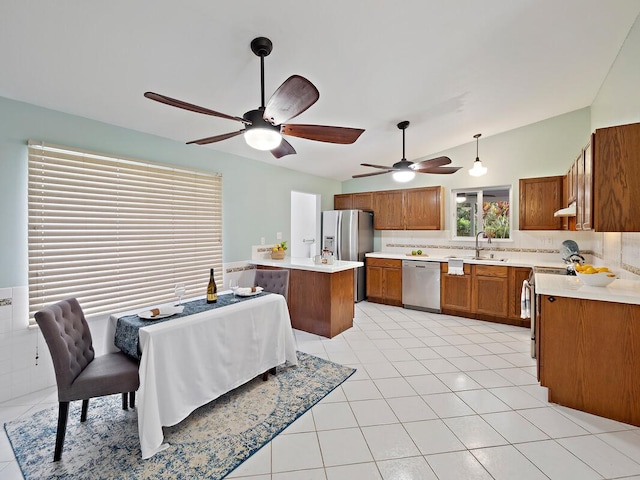 kitchen featuring a center island, sink, appliances with stainless steel finishes, decorative light fixtures, and light tile patterned flooring