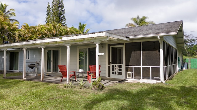 back of house with a lawn, a patio area, and a sunroom