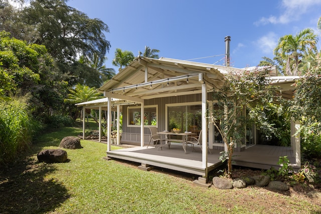 rear view of property featuring a yard and a wooden deck