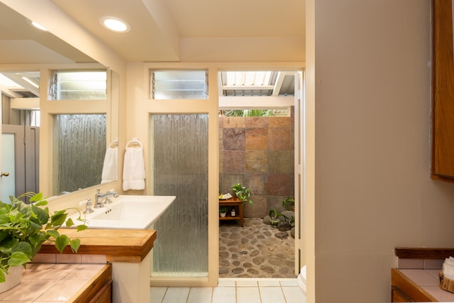 bathroom featuring vanity, a shower, and tile patterned floors