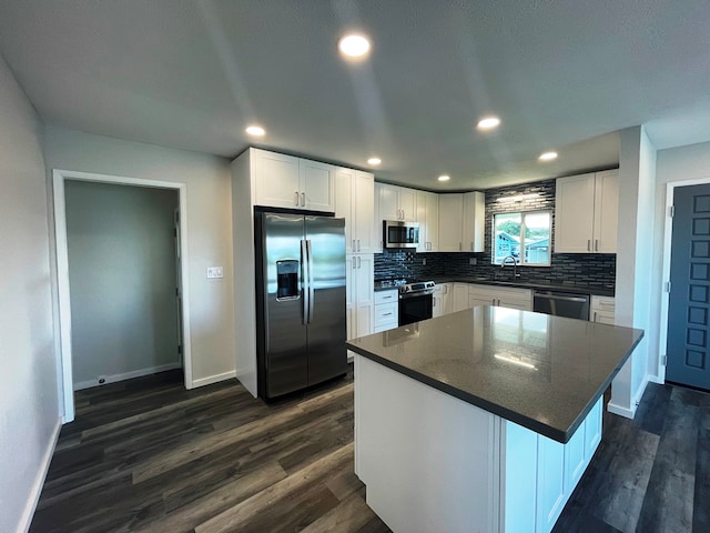 kitchen featuring white cabinetry, appliances with stainless steel finishes, dark hardwood / wood-style flooring, and a kitchen island